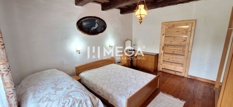 A bedroom with two beds, a wooden ceiling, and a floor with a wooden decor in a family house.