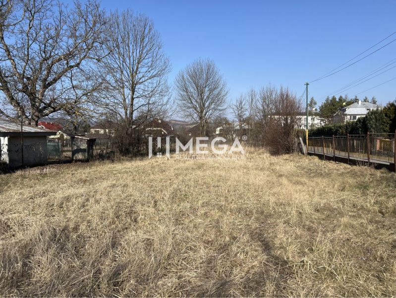 Lands - housing in Modra nad Cirochou, flat terrain, grassy vegetation, surrounding trees, urban development.