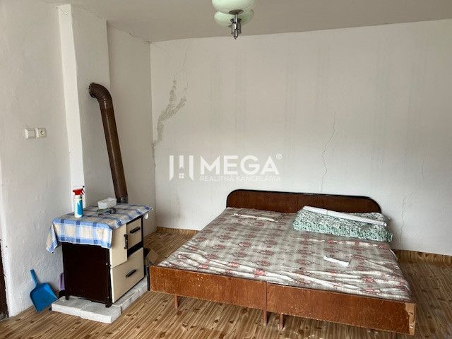 A room in a family house with a bed and a wooden decor floor.