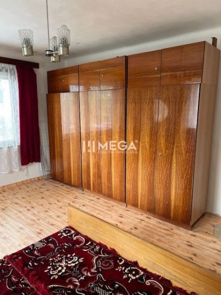 Bedroom with wood-patterned flooring and a built-in wardrobe in a family house.