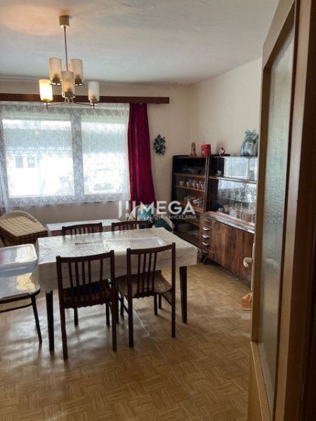 Dining room of a family house with a wooden decor floor, dining table, and display cabinet.