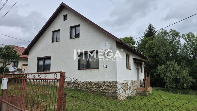 A family house in Zboj with a stone foundation and a garden, surrounded by greenery.