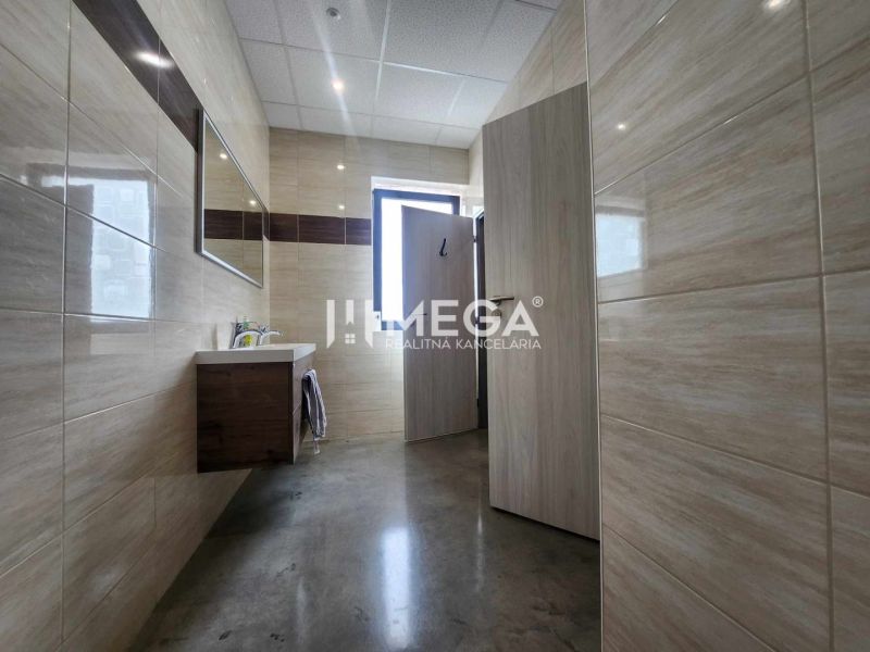 Bathroom with tiles and a sink in the office.