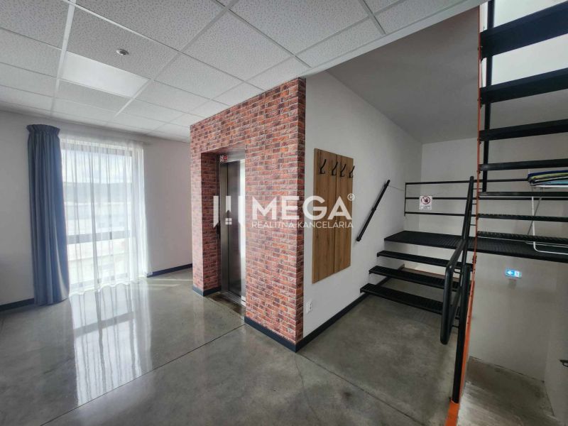 Interior of an office with a staircase, elevator, and curtain.