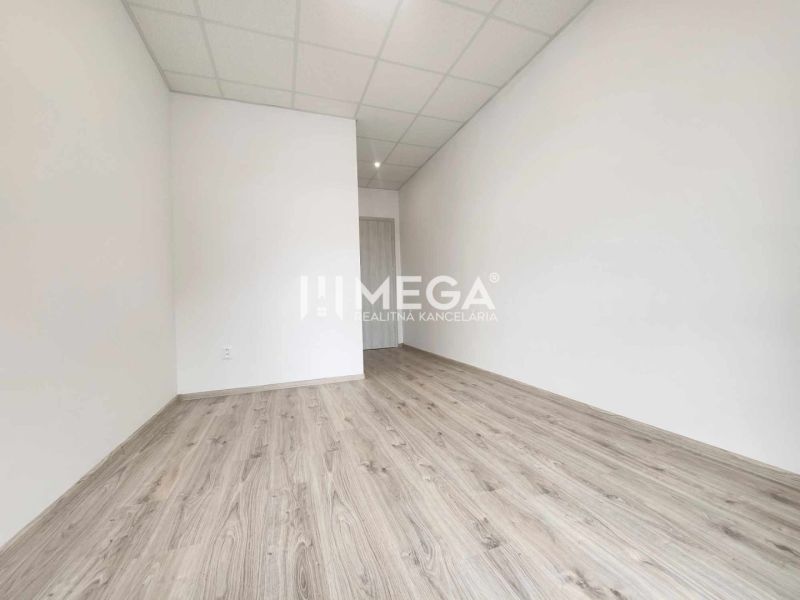A bright office with wood-patterned flooring and white walls.