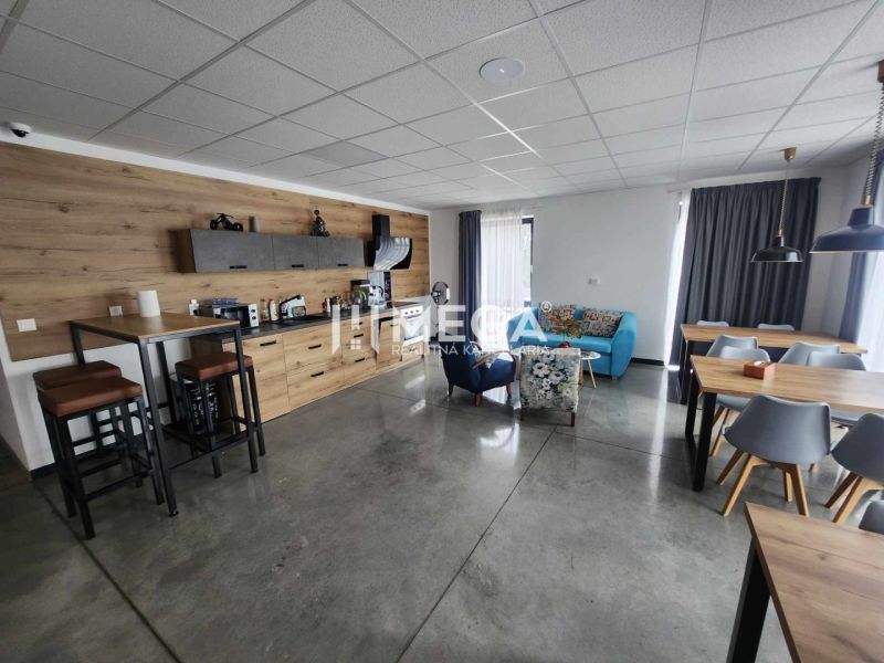 Offices with polished concrete flooring, stylish furniture, and decorative wooden paneling.