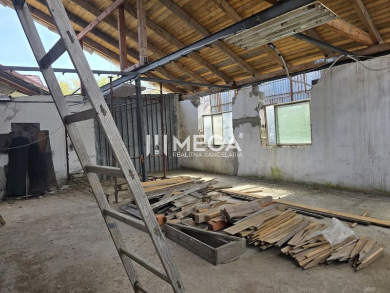 Interior of a family house with an unfinished roof, a ladder, and a pile of wood on the floor.
