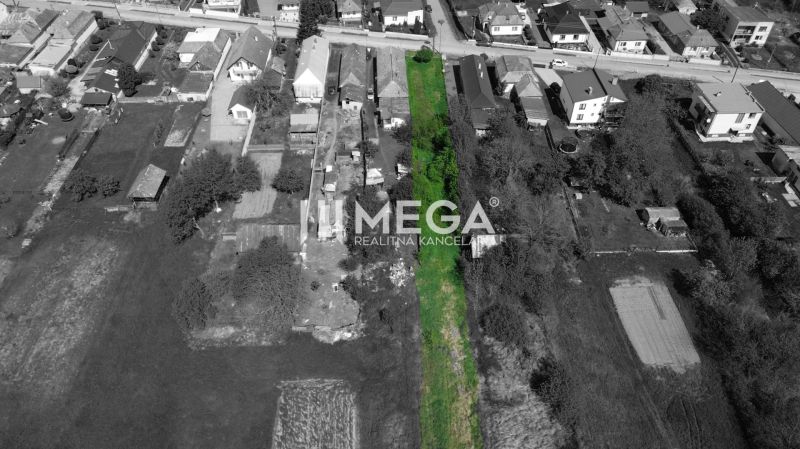 Land for sale in the village of Senné, designated for residential use, surrounded by greenery.
