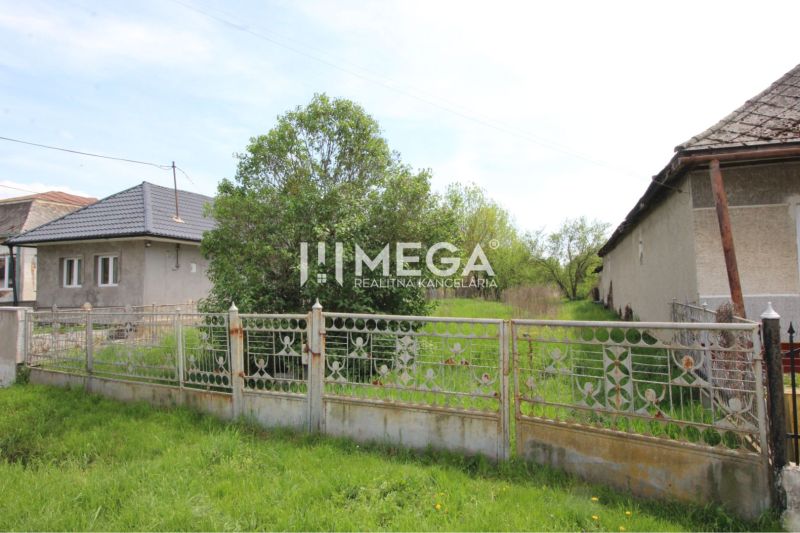 Exterior in Senné with an older fence and two houses, plots - living.