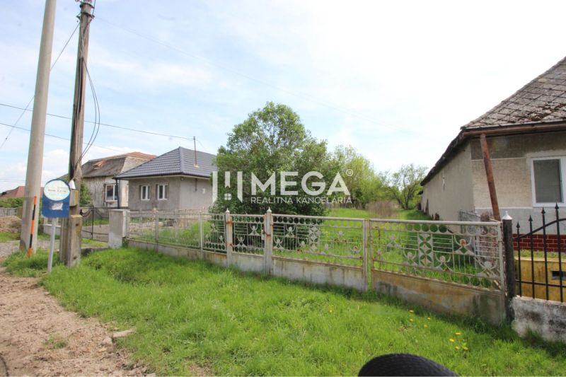 Plots - housing in Senné with a fence and houses in the background.
