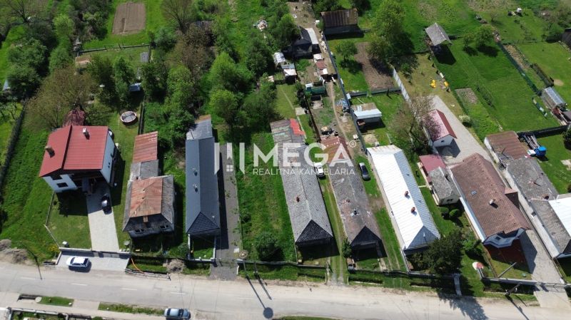 Aerial view of residential plots in Senné with gardens and houses.