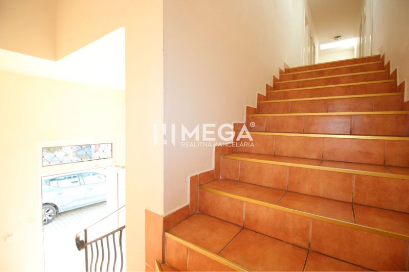 A staircase in commercial premises with light walls and doors.