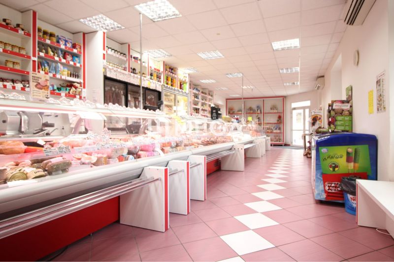 Interior of retail spaces with groceries and freezing boxes, tiled floor.
