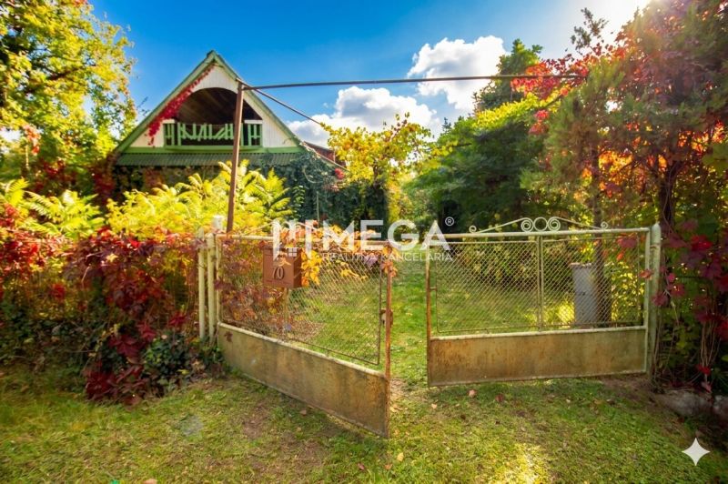 A family house in Petrovce surrounded by greenery and a garden with a gate.