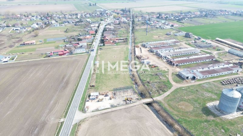 Aerial view of manufacturing facilities in the village of Hriadky surrounded by agricultural fields and a road.