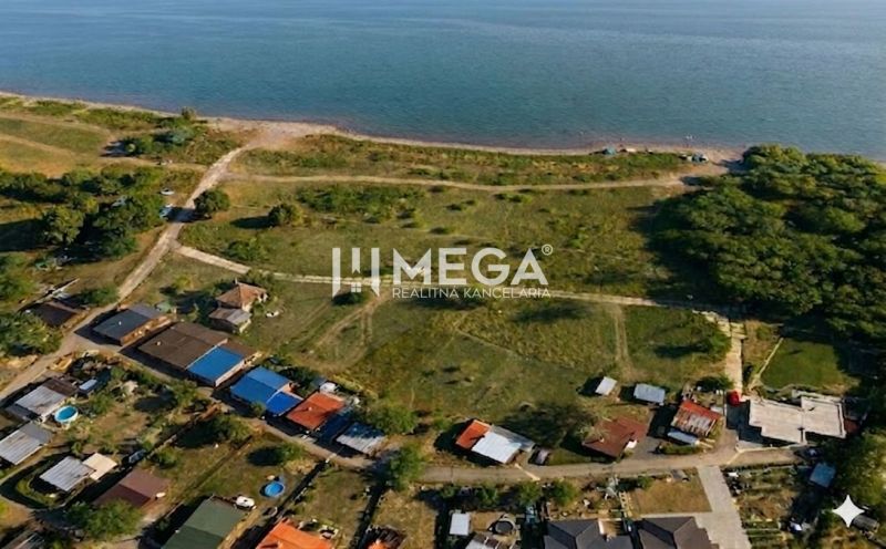 Aerial view of residential plots near a water body in the village of Vinné.