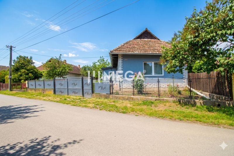 A family house in Veľká Ida with a blue facade and a garden, surrounded by a fence.