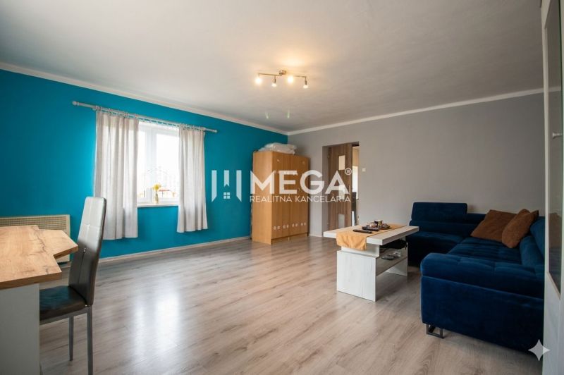 Living room in a family house with a wooden decor floor and a blue wall.