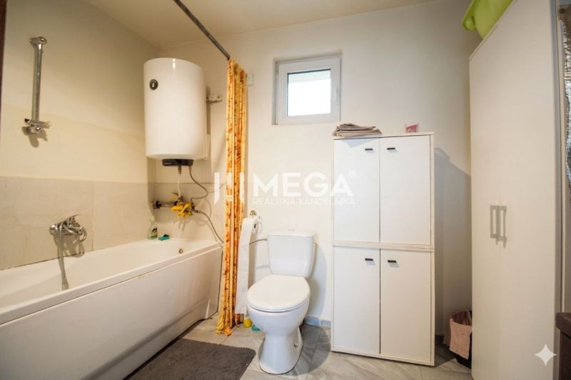 A bathroom in a family house with sanitary equipment and storage cabinets.
