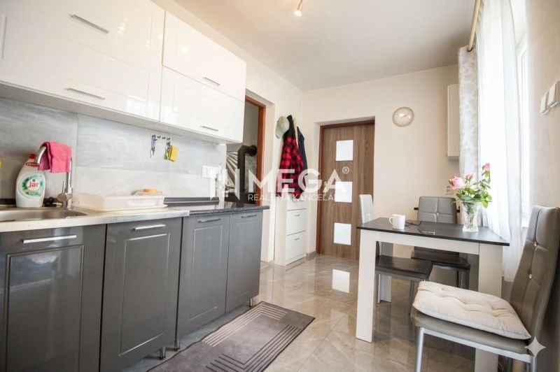 A kitchen in a family house with white and gray cabinets and a dining table.