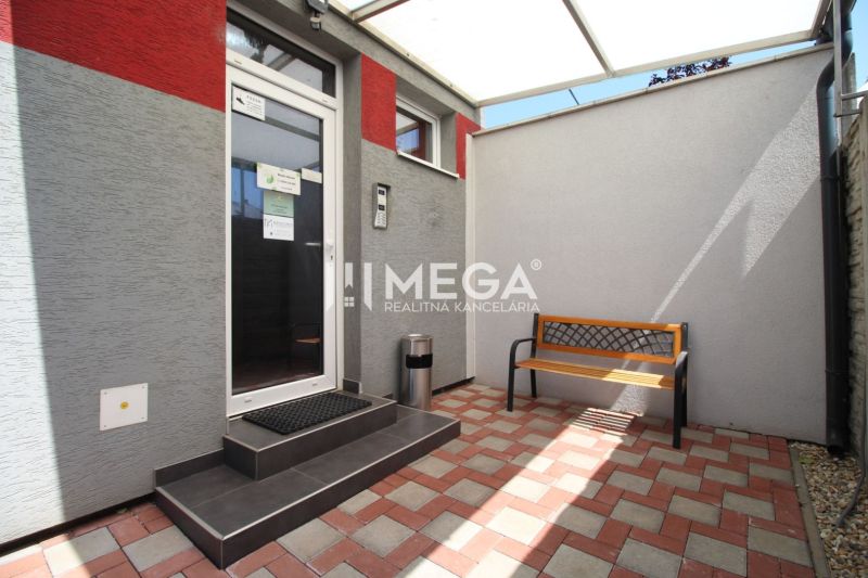 A courtyard in office premises on Sama Chalupka Street in Michalovce with a bench and paving.