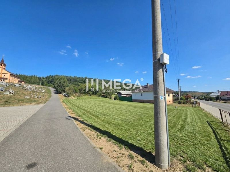 A road in Slovenská Volová with greenery, houses, and a church, Land - residential.