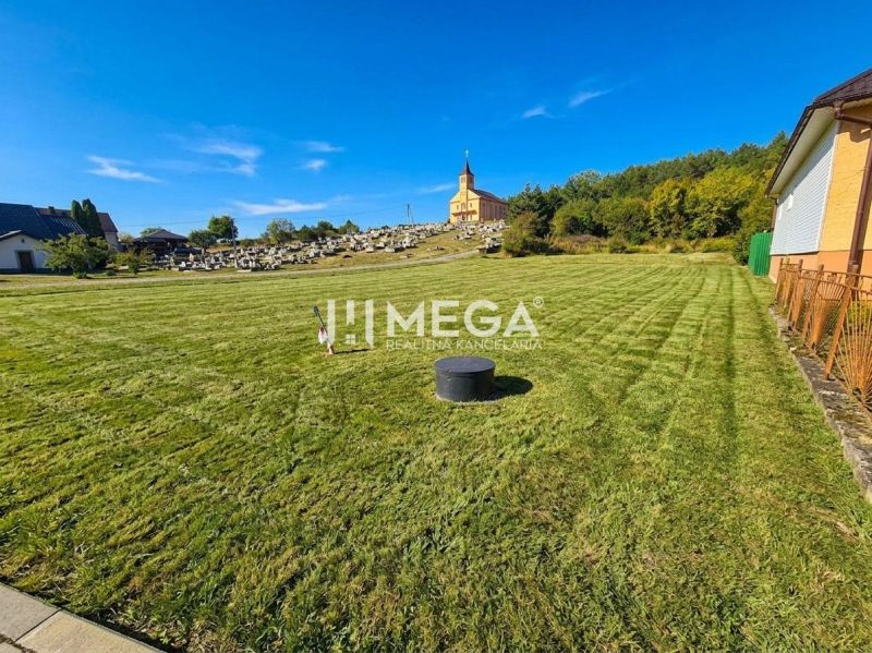 Residential plots in Slovenská Volová with a church and cemetery in the background.