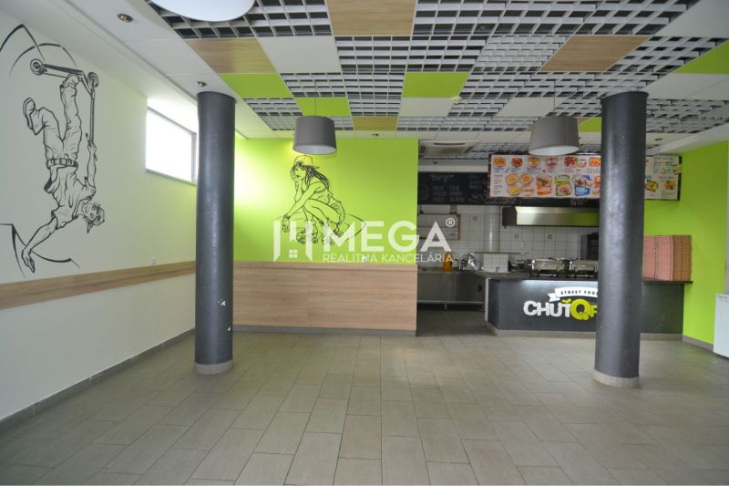 Interior of commercial spaces with wall decorations and an open kitchen.