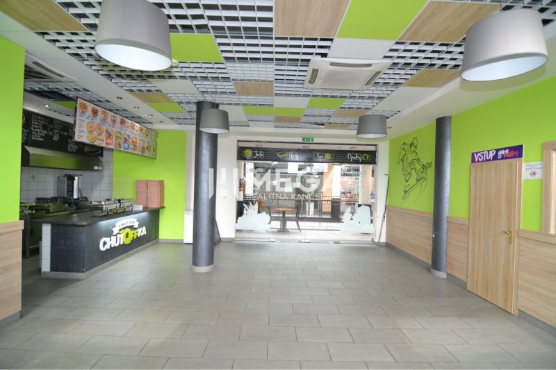 Commercial spaces with a dining counter, wooden decor flooring, colorful interior elements.