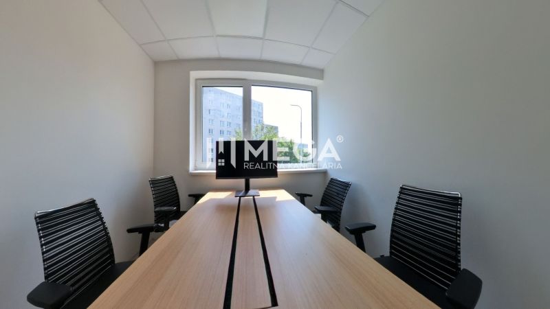 Office interior with a long table, four chairs, and a window.