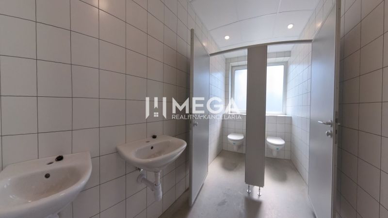 Restroom facilities with sinks and toilets in offices, tiles on the walls.
