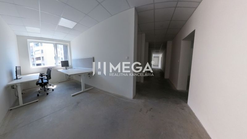 Offices with desks and chairs, with a view of the city through the window.