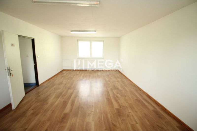 An office interior with wood-patterned flooring and a large window.