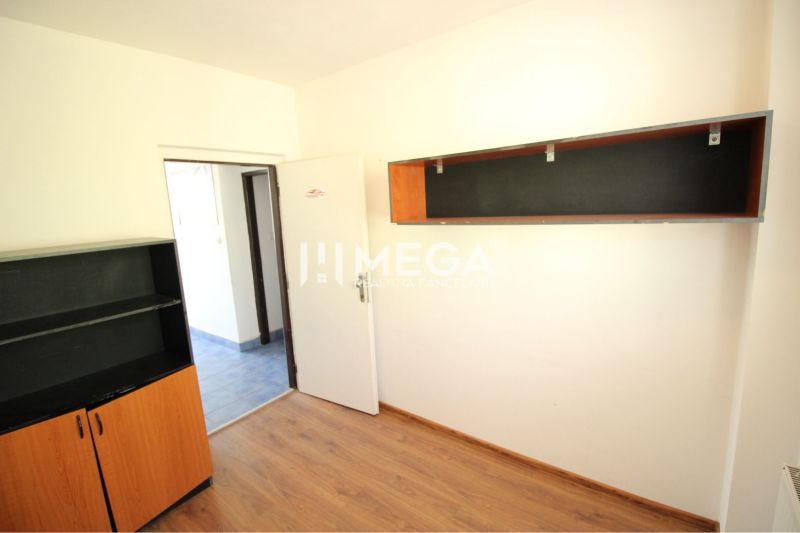 A room with shelves, white walls, and a wooden decor floor in an office.