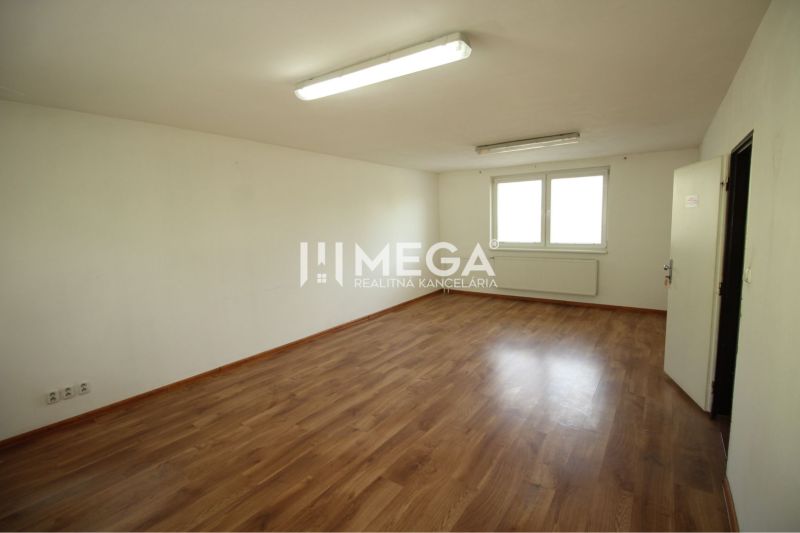 Spacious offices with wood-patterned flooring, white walls, and windows.