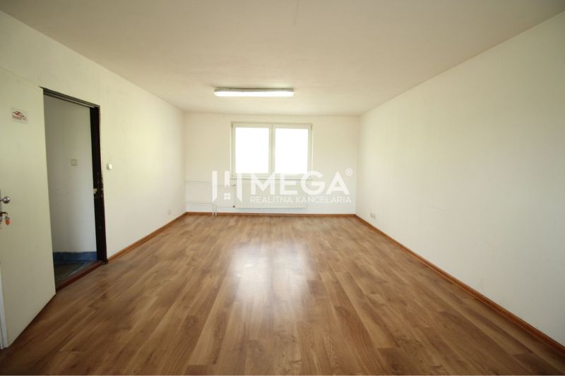 Spacious office with wood-patterned flooring and white walls.