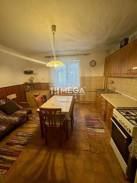 A kitchen in a family house with wooden decor on the chairs and a large table.