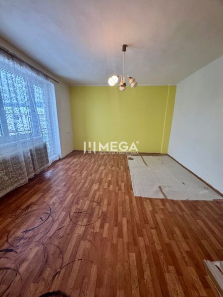 A room with a wooden floor decor and a yellow wall in a family house.