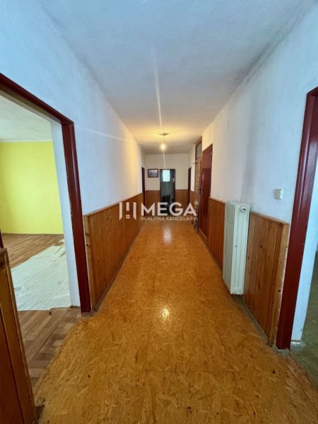 A hallway in a family house with wooden paneling and OSB board flooring.