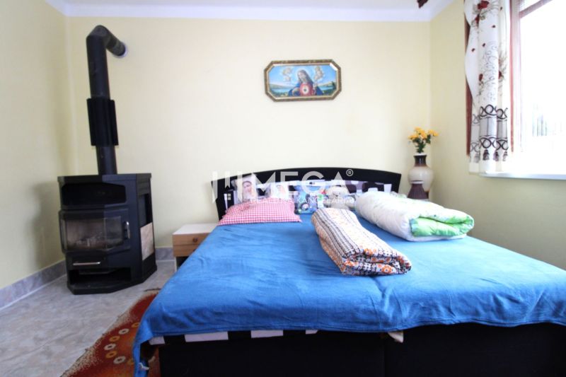 Interior of a family house with a bed, stove, and colorful accessories.