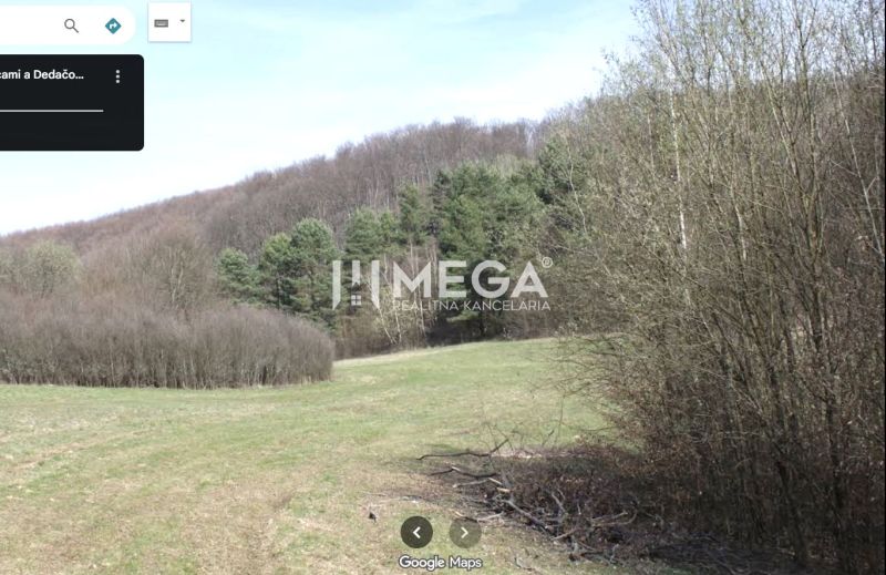 Agricultural and forest land in Maškovce with a view of wooded hills.