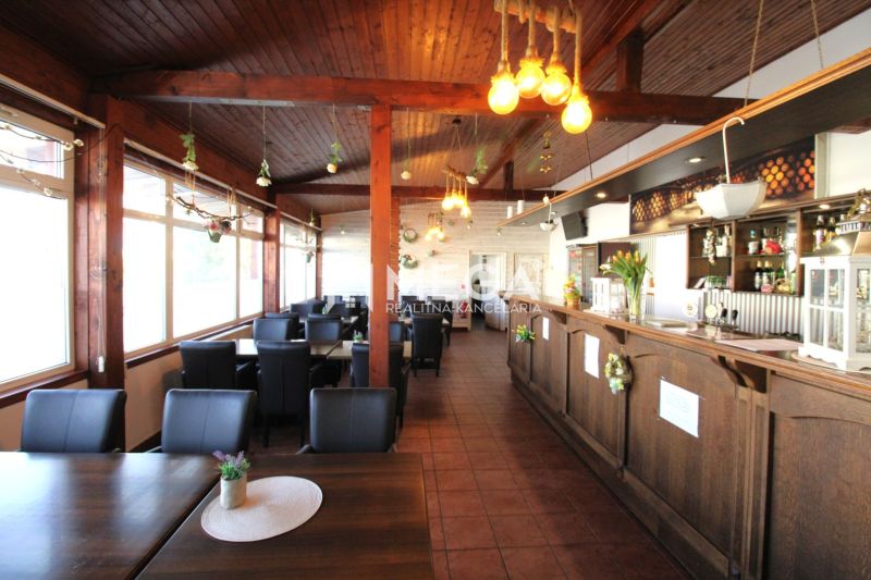 Interior of dining spaces with wooden elements, black chairs, and decorative lights.