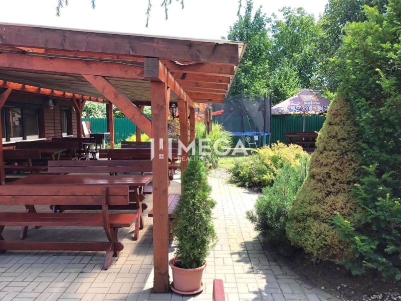 Vranov nad Topľou, Budovateľská: Gastro premises with wooden seating and greenery on the terrace.