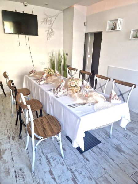 A table set with decorations, a floor with wooden decor, chairs in dining spaces.