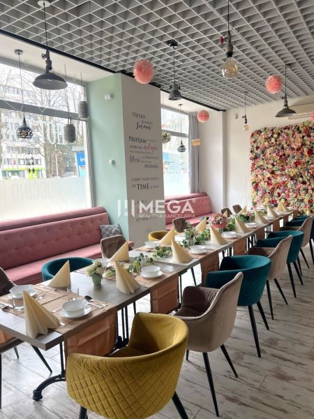 Gastro premises with a decorated table, flower wall, and floor with wooden decor.