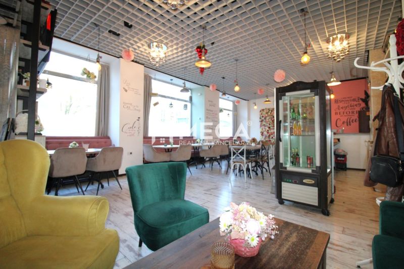 The interior of a café with wooden decor on the floor, comfortable armchairs, and decorations on the ceiling.