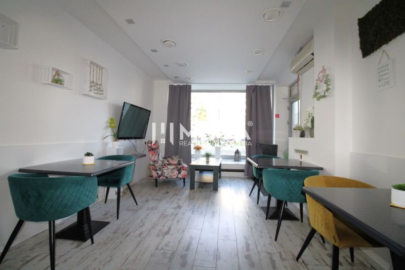 Gastro premises with colorful chairs and a wooden decor floor.