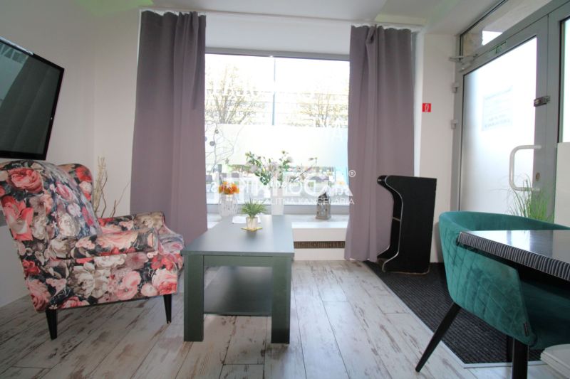Interior with wood-patterned flooring, flowers, chairs in a dining area.
