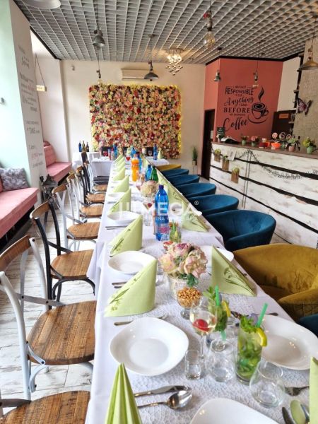 Interior of dining spaces with a decorative wall and a set table with colorful napkins.