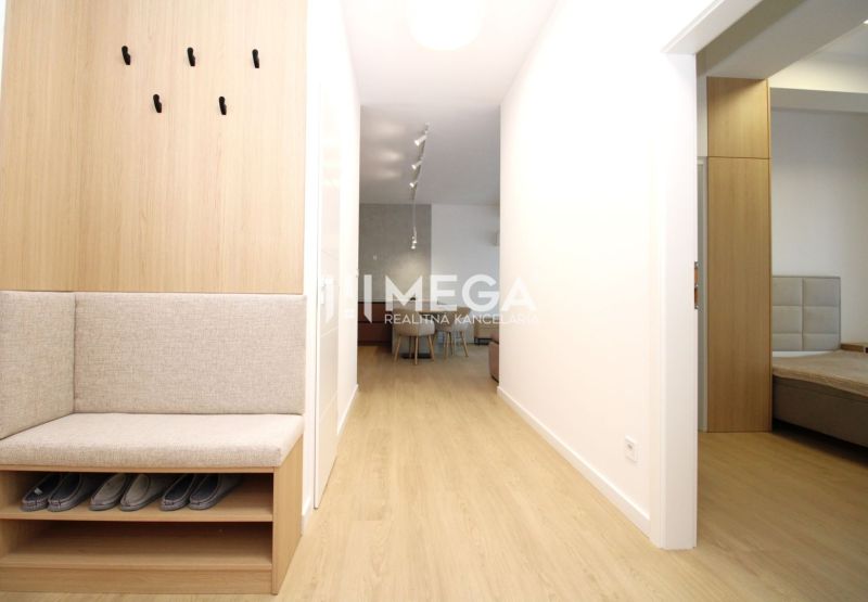 A hallway in a 3-room apartment with a wooden decor floor and built-in seating.